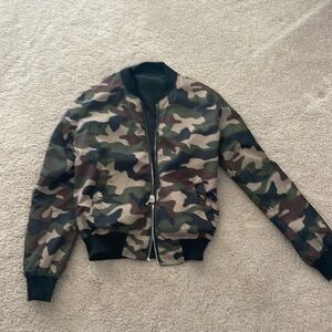 Reversible jacket one side is all black. The other size is green camo
